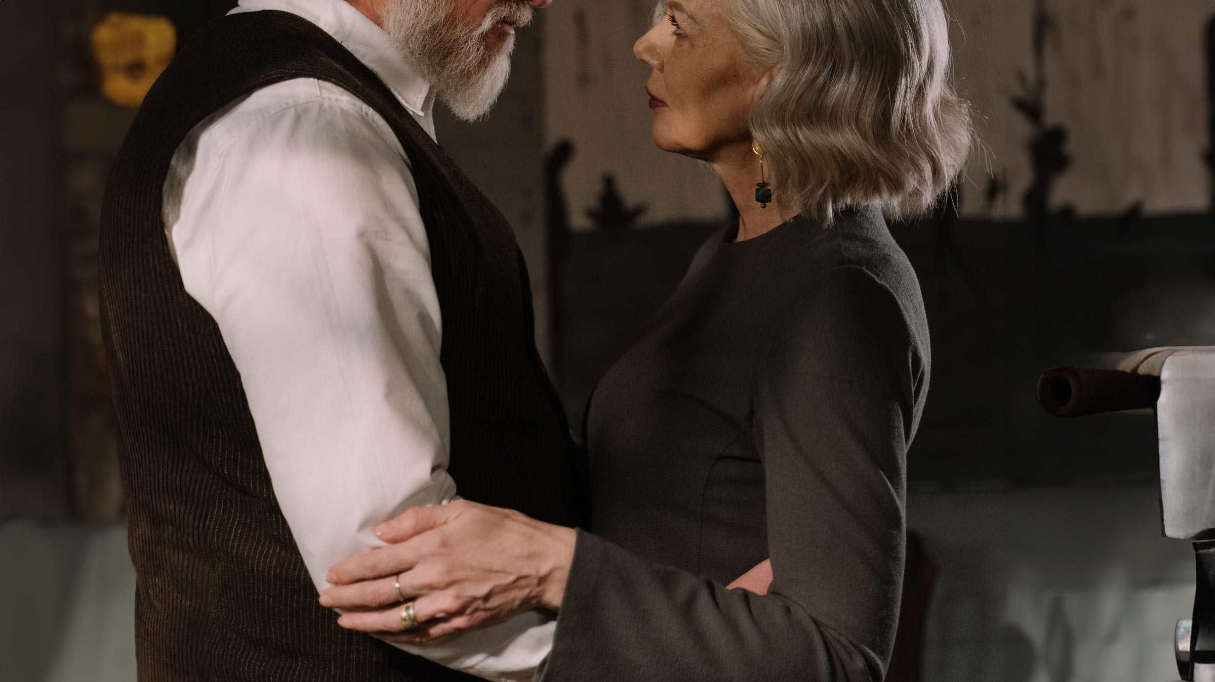 Older male escort and woman looking at each other