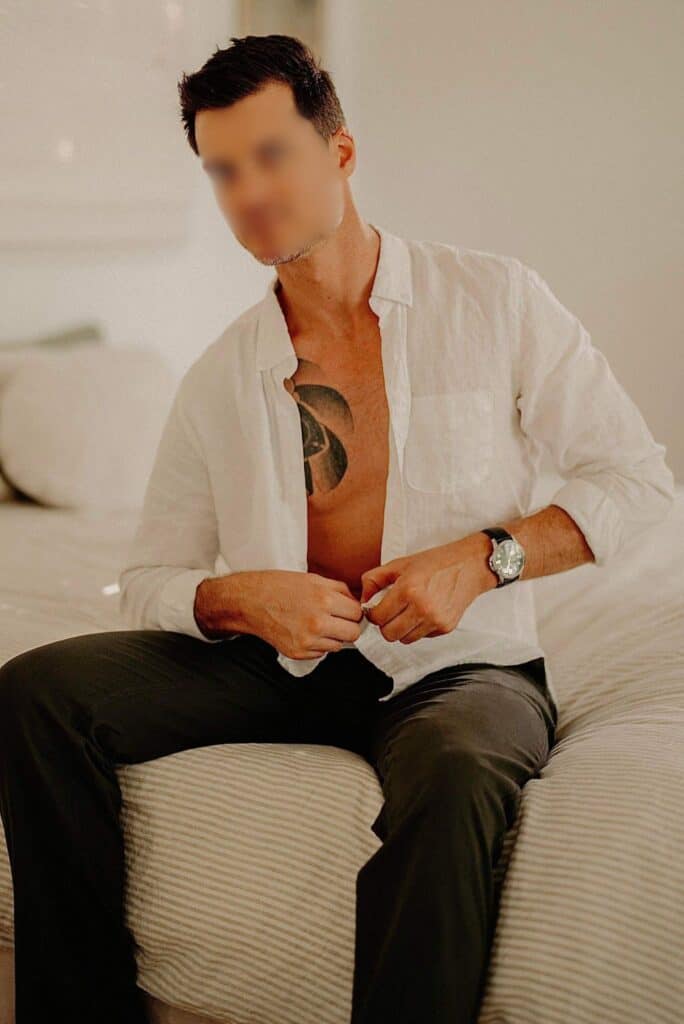 Companions 9 a male escort sitting on a bed