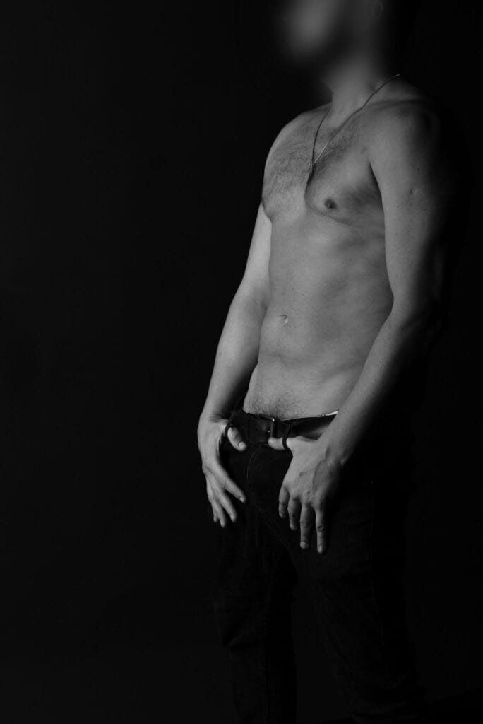Elegant male companion shirtless with hands in pant pockets