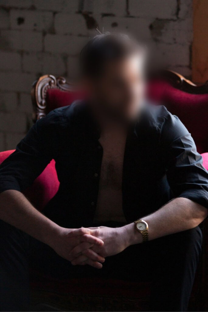 Male companion resting on sofa, relaxed and approachable.